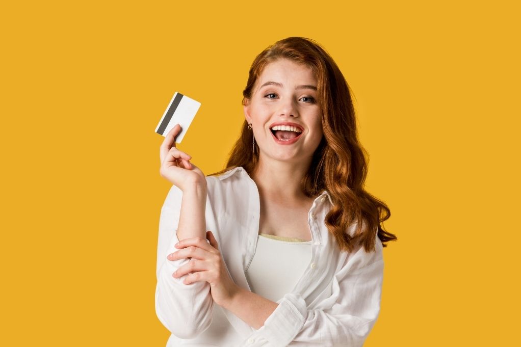 Young smiling women holding a Visa gift card