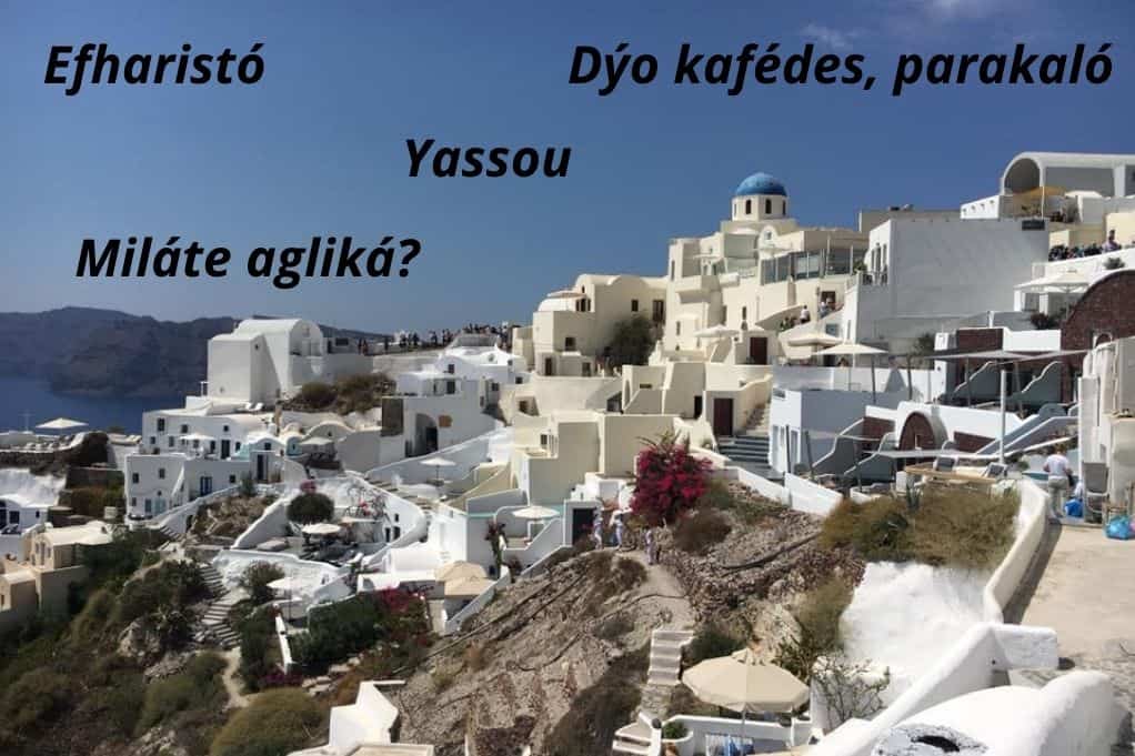 Basic Greek phrases overlaid on a picture of Oia.