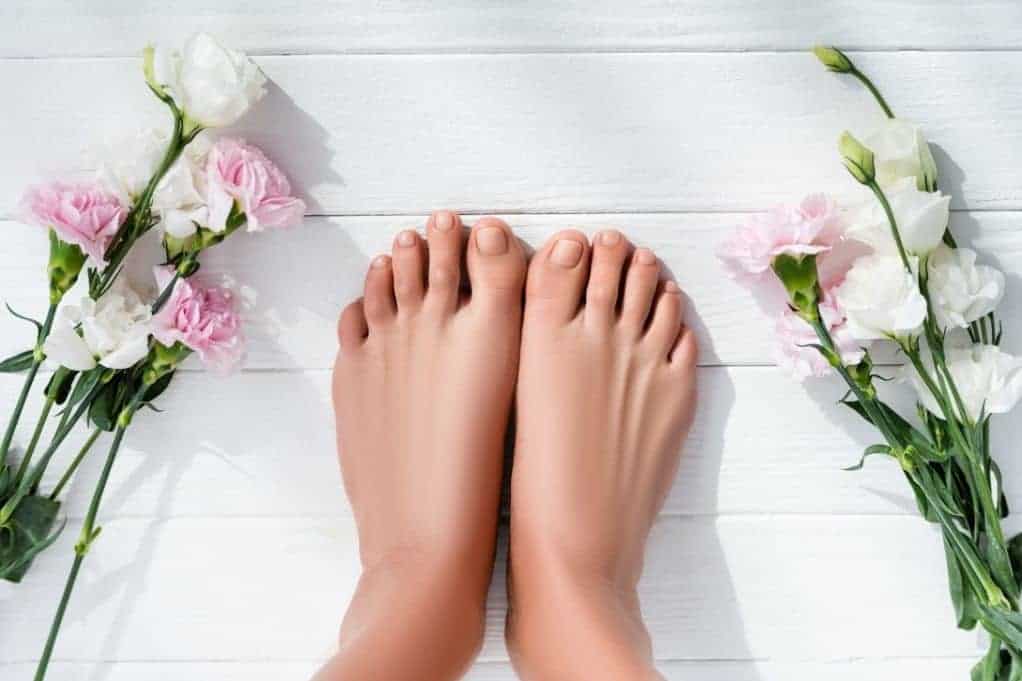 Top of woman's feet with flowers around both sides