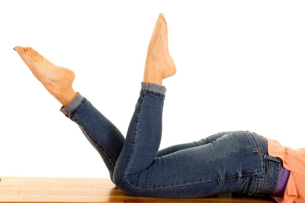 Woman laying on stomach, feet in the air behind her