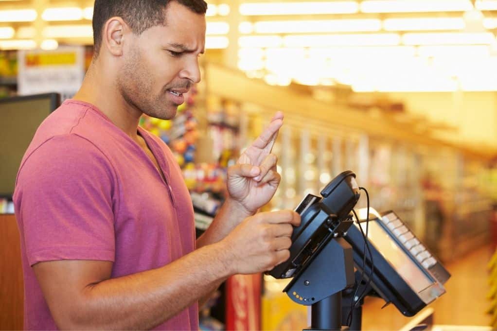 Man at register, hoping Chime SpotMe covers his overdraft