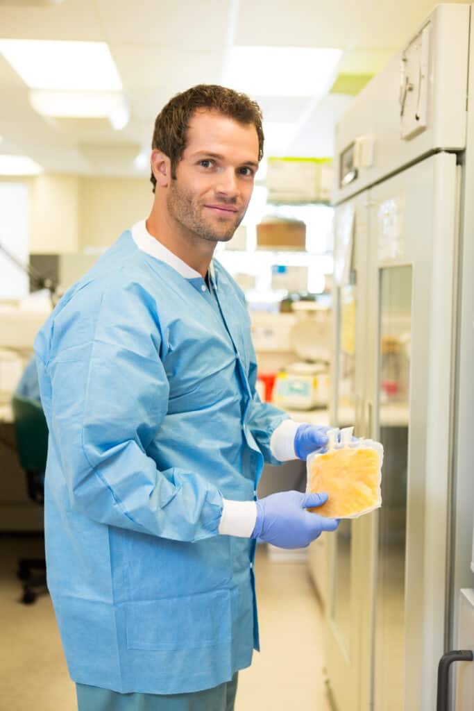 lab tech holding a bag of plasma