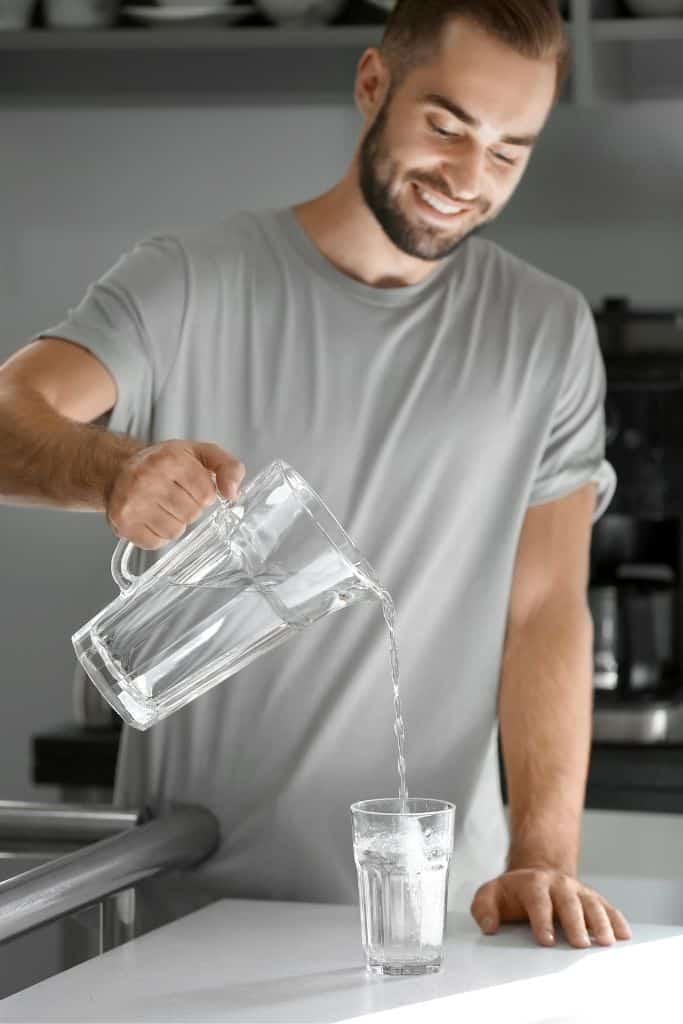 fit man pooring a glass of water