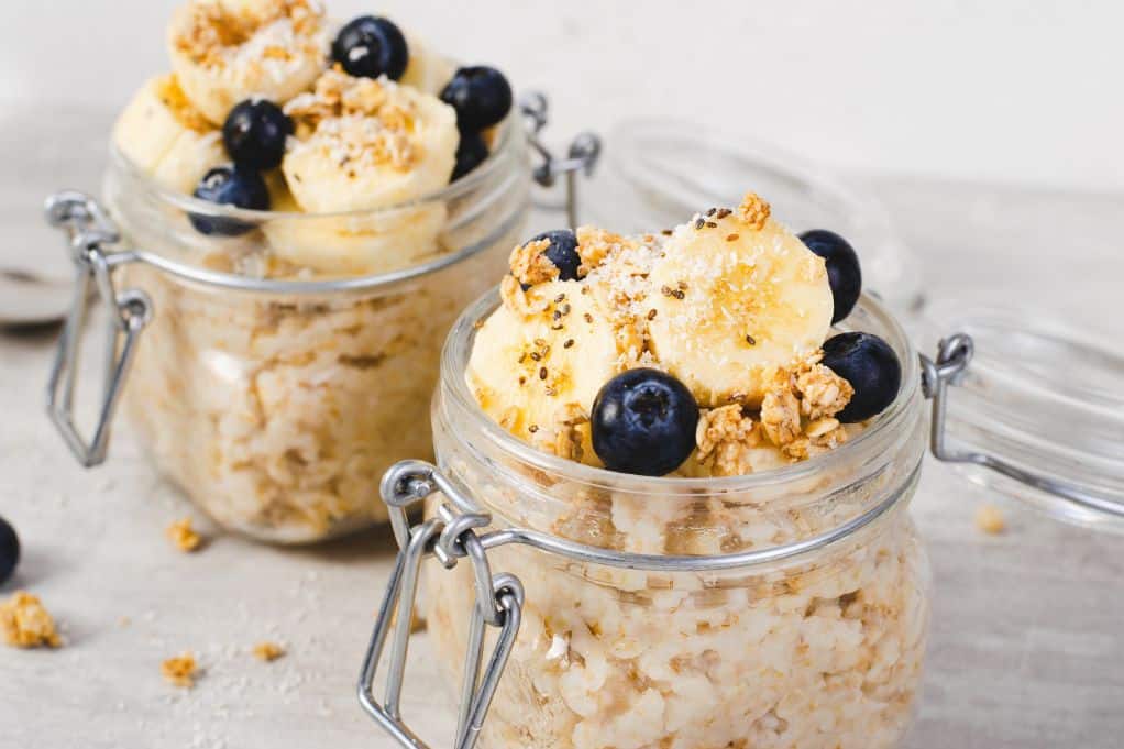 glass jars of overnight oats topped with fruit