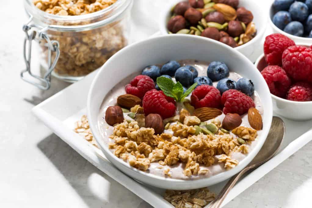 bowl of Greek yogurt topped with nuts and fruit