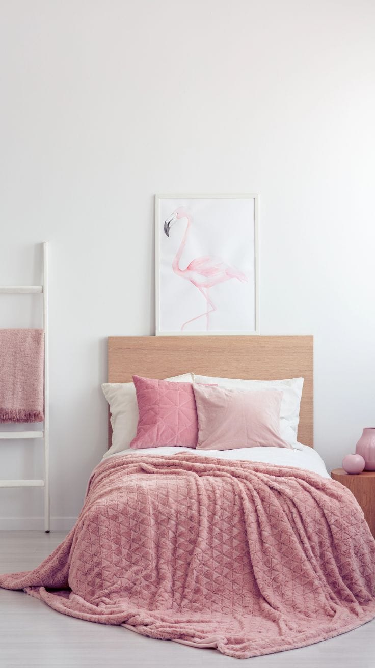 a white bedroom with pink bedding and decor